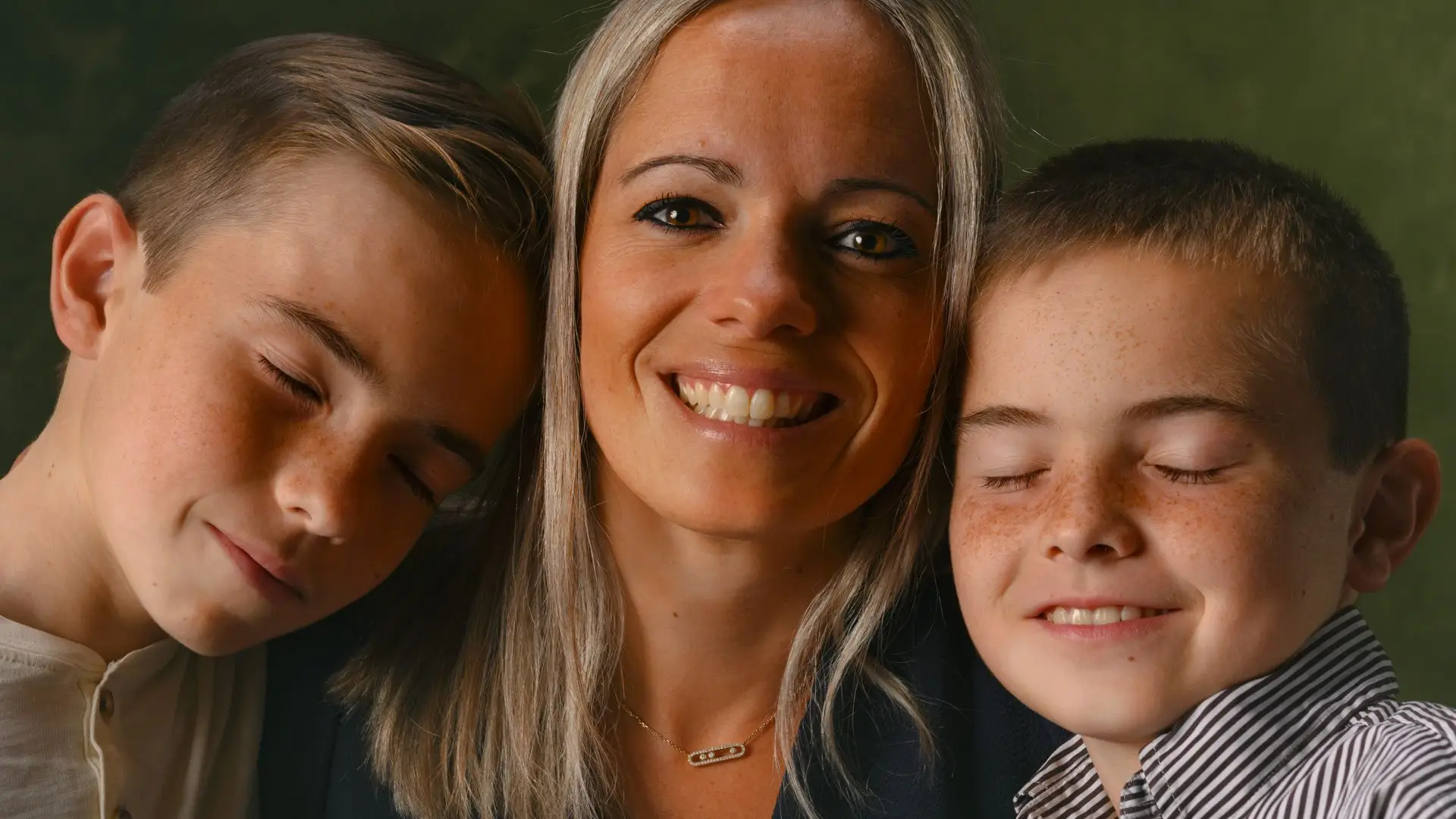 Une mère et ses deux fils serrés l'un contre l'autre, portrait de famille en studio